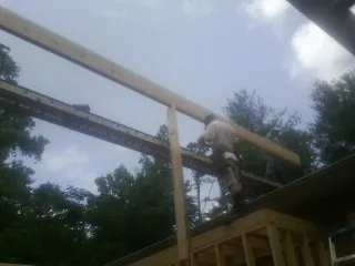 Carpenter setting a ridge beam over a new addition frame — Ice Dam Removal by Roofing Brothers in Mt Baldy