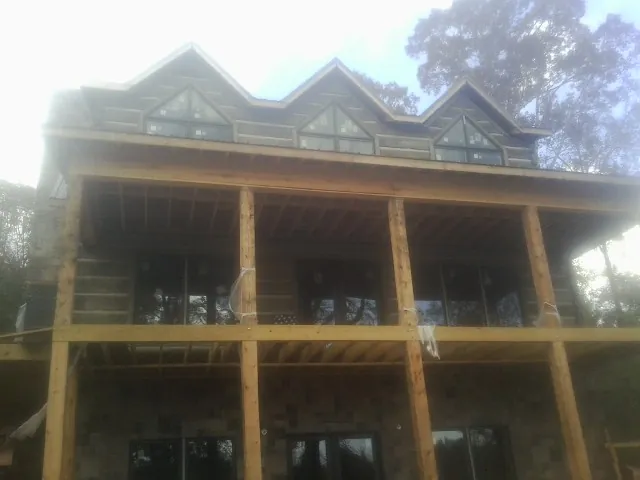 Dormers and porch framing on a large log home under construction — Roof Coating work by our crew in Mt Baldy